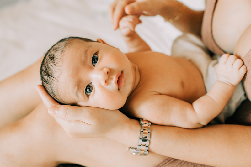 Newborn Photographer, a mother holds her baby in her arms